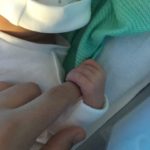 Newborn baby Isla holding daddies finger.