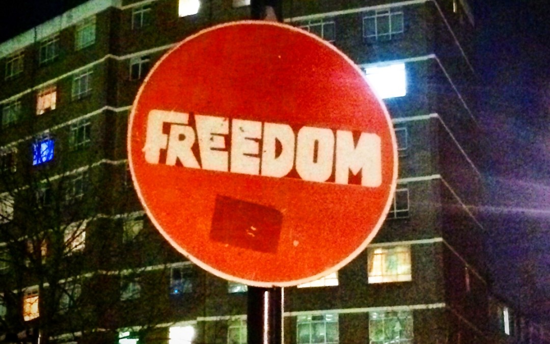 Freedom street art on a stop road sign.