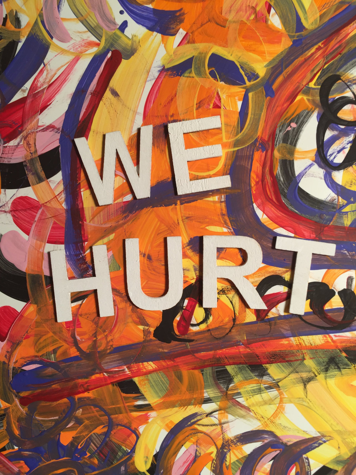 Acrylic paint on poster board plus painted wooden letters to spell 'We hurt'